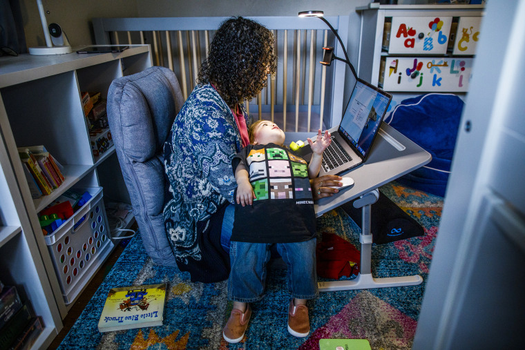 Image:; A mother works at her make shift office set up in her daughter nursery.