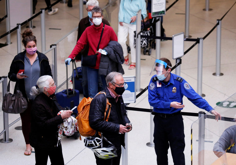 A TSA worker directs travelers to the next station at a security checkpoint at Seattle-Tacoma International Airport in SeaTac, Wash., on April 12, 2021.