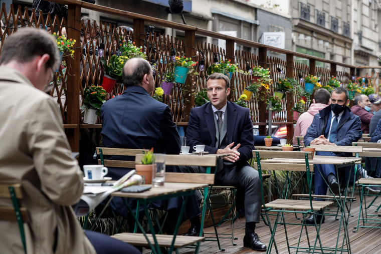 Image: French President Emmanuel Macron and French Prime Minister Jean Castex drink coffee at a cafe terrace in Paris