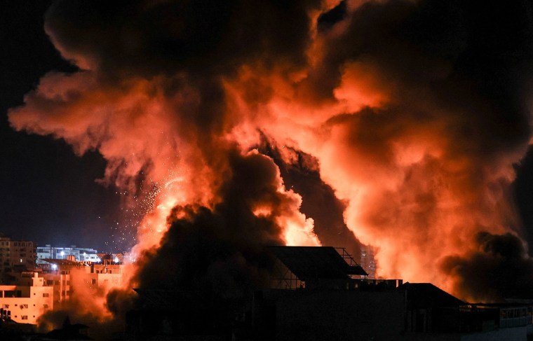 Image: Explosions light-up the night sky above buildings in Gaza City as Israeli forces shell the enclave,