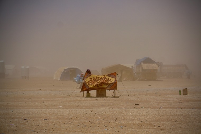 Image: IDPs setting up shelter just outside of a medical clinic in a camp on the outskirts of Tal Afar, Iraq, a city occupied by ISIS.