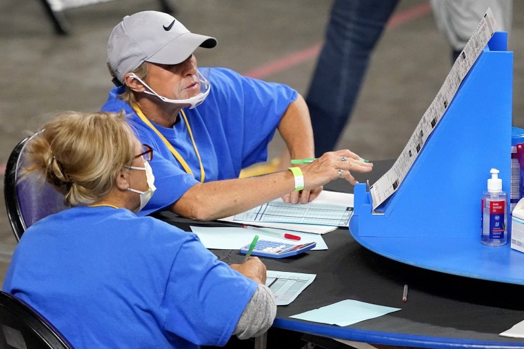 Contractors with Cyber Ninjas examine and recount ballots cast in the 2020 general election in Maricopa County on May 6, 2021, in Phoenix.