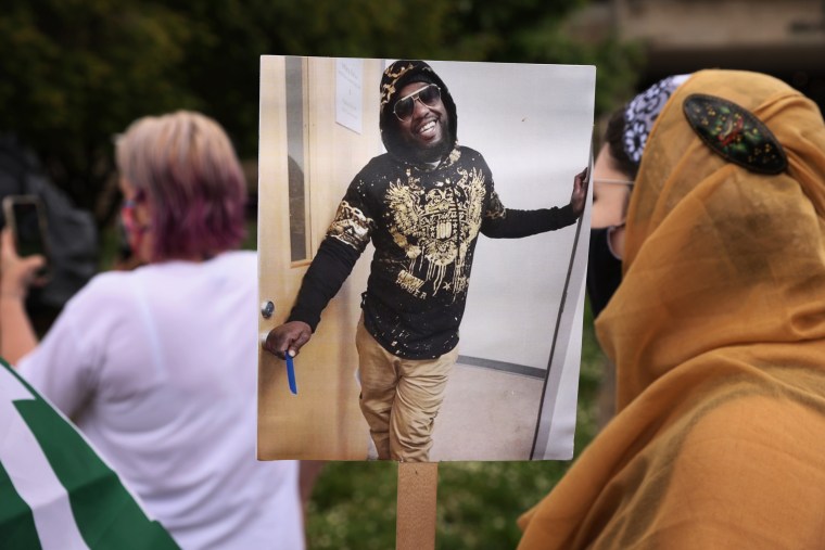 A protester holds Marcus Smith's picture during a demonstration outside City Hall in Greensboro, N.C.