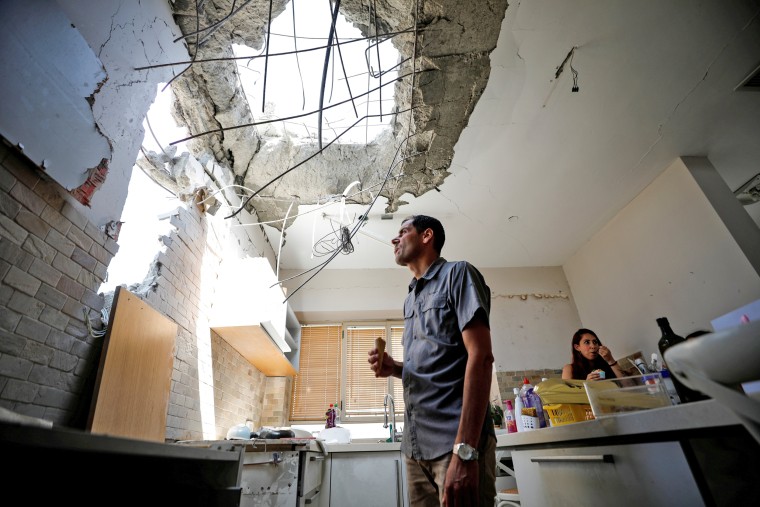 Image: Adi Vaizel, looks at the damage caused to the kitchen of his house after it was hit by a rocket launched from the Gaza Strip earlier this week, in Ashkelon