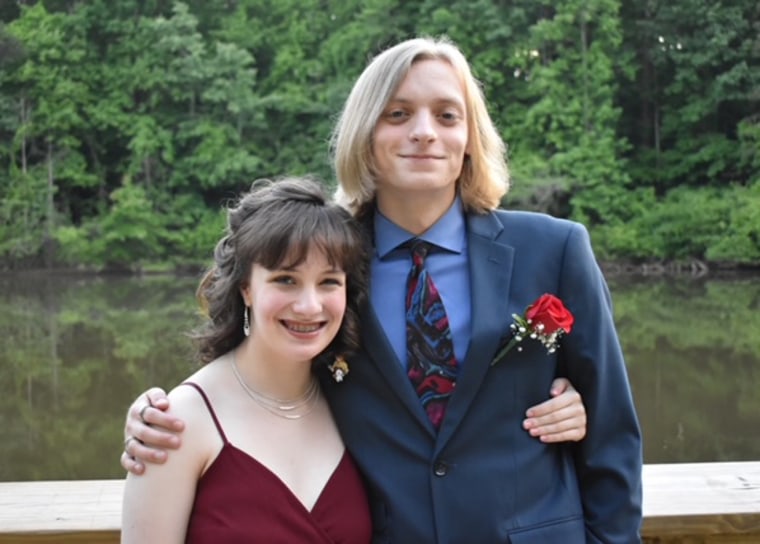 young woman stands next to a teenage boy in prom clothes