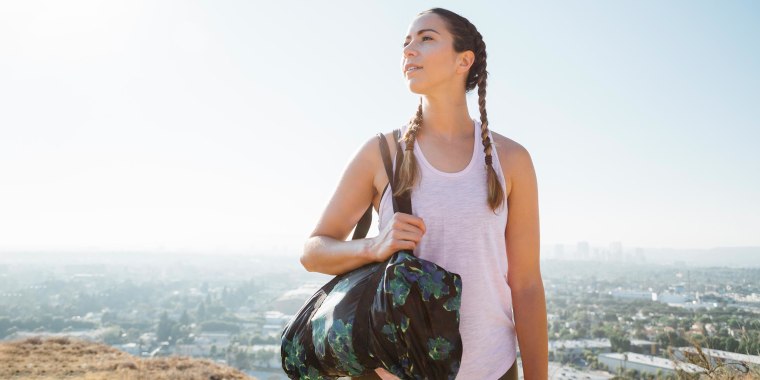 Woman carrying sports bag on hilltop in Los Angeles