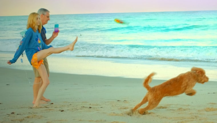 Sarah Kate Frey tosses a frisbee for Alice Eloise with her foot.