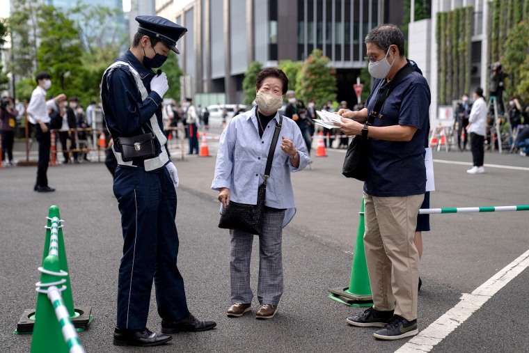 Image: A woman arrives to receive the Moderna coronavirus vaccine at the newly-opened mass vaccination center in Tokyo on May 24, 2021.