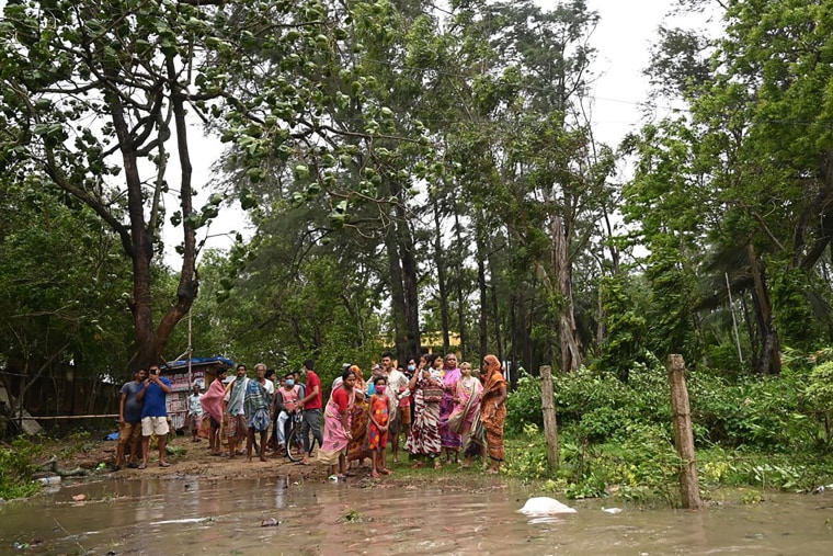 Image: Residents stand near a shelter while sea water floods a road in in Digha, India on Wednesday.