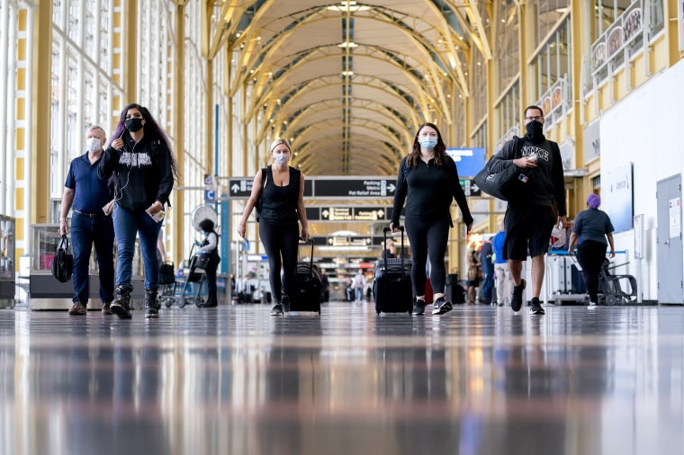 Image: Travelers walk through Ronald Reagan National Airport in Arlington, Va., on May 25, 2021.
