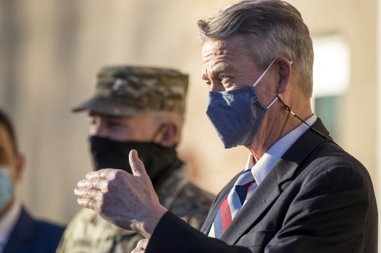 Gov. Brad Little, with Major General Michael J. Garshak, explains the mission of the Idaho National Guard assisting health workers during the coronavirus pandemic at Saint Alphonsus Health Plaza in Meridian, Idaho on Dec. 3, 2020.