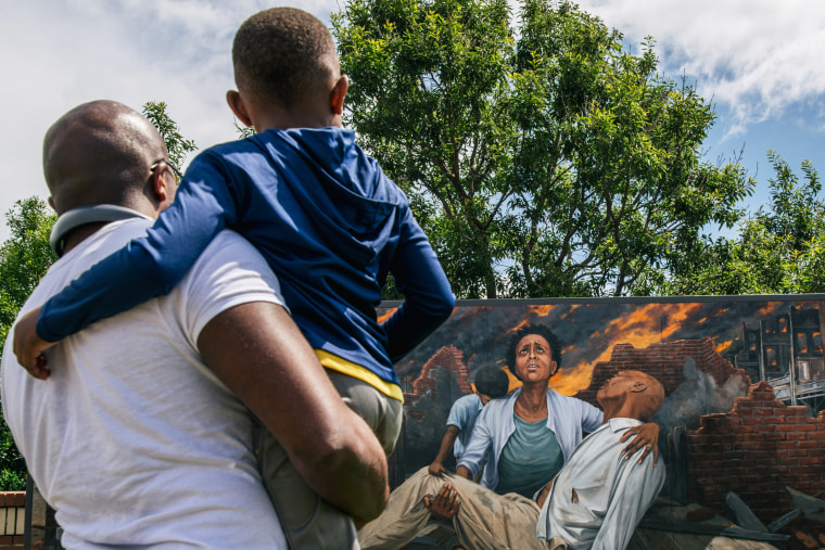 IMAGE: Nehemiah Frank teaches his cousin David McIntye II about the Tulsa massacre