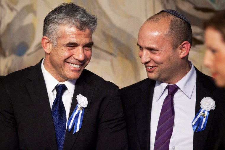 Israeli politicians Yair Lapid, left, and Naftali Bennett speak at a reception marking the opening of the 19th Knesset on Feb. 5, 2013, in Jerusalem.