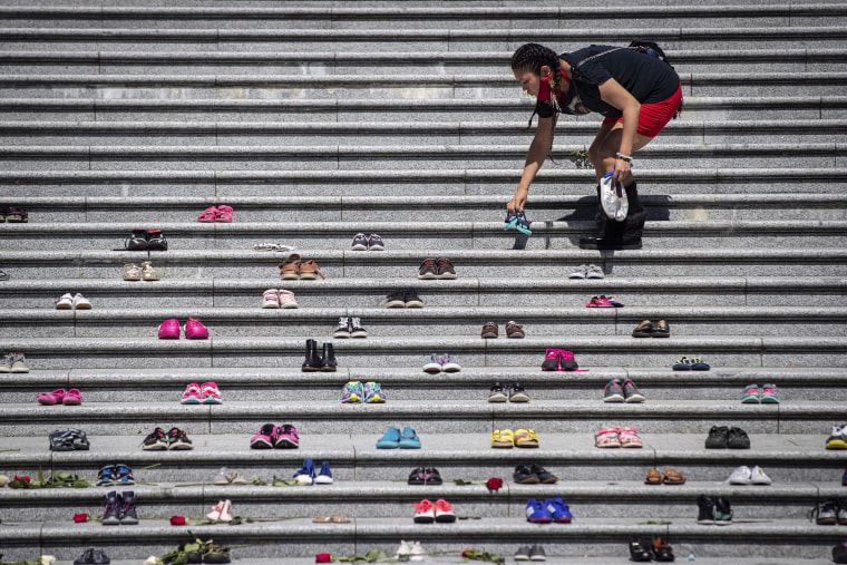 Image: Lorelei Williams places children's shoes on the steps of the Vancouver Art Gallery