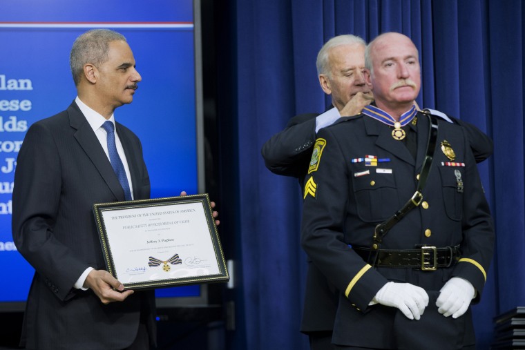 Attorney General Eric Holder and Vice President Joe Biden award the Medal of Valor to Sgt. Jeffrey Pugliese from the Watertown, Mass., Police Department on Feb. 11, 2015.