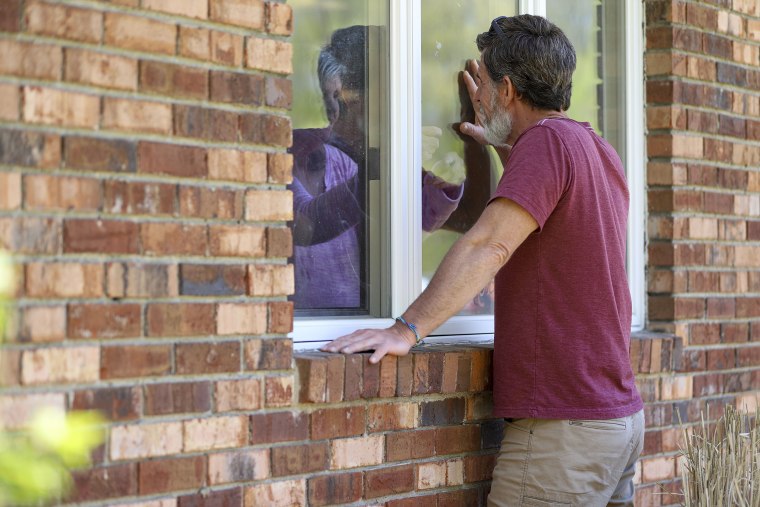 Image:; A man talks with his mother through her apartment window at a nursing home, May 14, 2020 in Windsor, Conn.