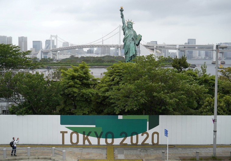 Image: An advertising board for the postponed Tokyo 2020 Olympic Games near Tokyo's Statue of Liberty replica