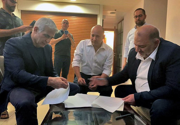 Image: Mansour Abbas, Yair Lapid and Naftali Bennett signing a coalition agreement.