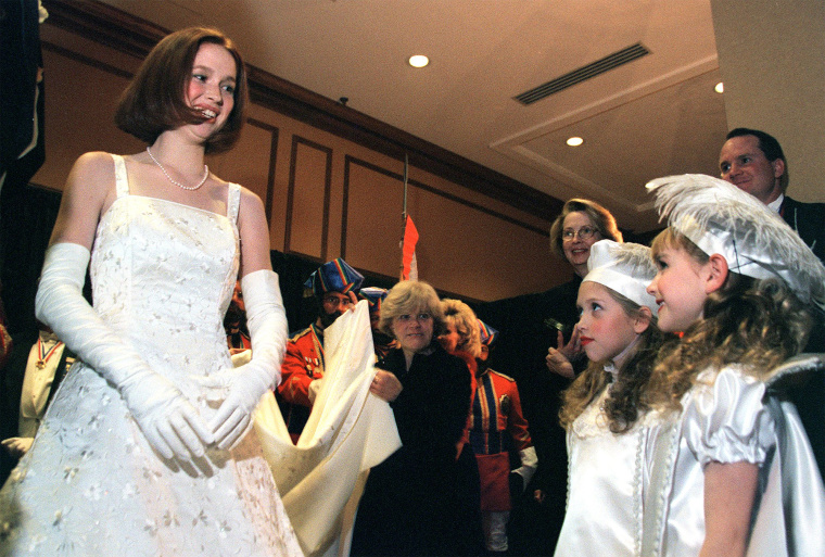 The new Queen of the court of Love and Beauty, Miss Elizabeth Claire Kemper speaks briefly with her two pages Katy Angevine, left, 8, and Jacqueline Probst, 7, before taking the stage to accept her crown from the veiled prophet on Dec. 23, 1999.