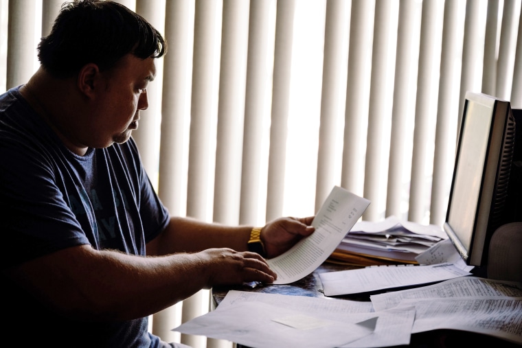 Image: Robert Jones looks over documents relating to his son's arrests.