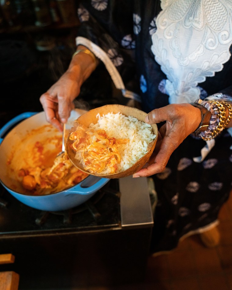 Harris plating her dish on a bed of white rice.