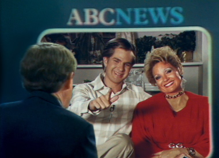 Andrew Garfield (as Jim Bakker) and Jessica Chastain (as Tammy Faye Bakker) undergo a grilling on "Nightline" in "The Eyes of Tammy Faye."
