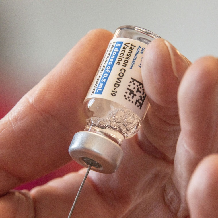 A hand loads a COVID-19 vaccine into a syringe