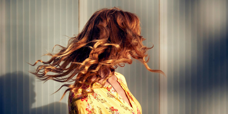 Red-haired woman shaking her hair