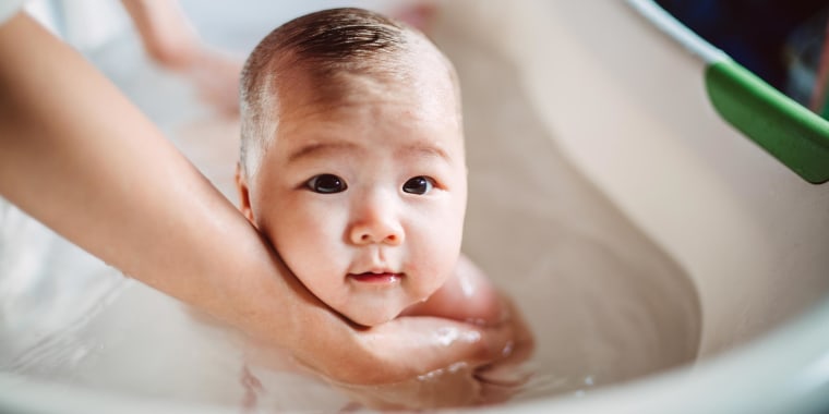 New born baby having tub bath joyfully