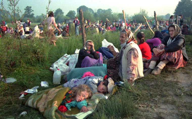 Refugees from the overrun U.N. safe haven enclave of Srebrenica who had spent the night outdoors gather outside the U.N. base at Tuzla airport on July 14, 1995.