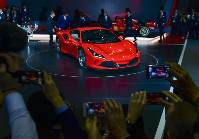 Image: Attendees take pictures of the Ferrari NV F8 Tributo on the opening day of the Geneva International Motor Show on March 5, 2019.