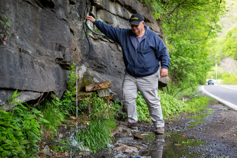 McDowell County Commissioner Cody Estep draws water from a mountain spring, the only source of drinking water for many residents.