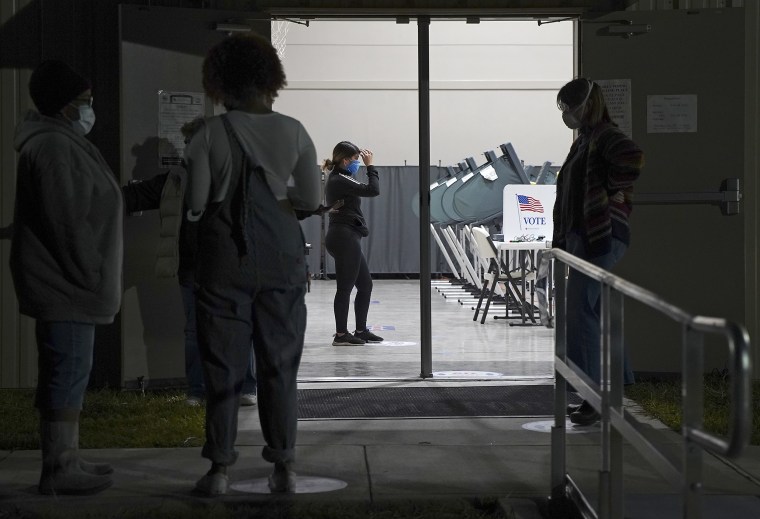 Image: Voters wait to cast their ballots at a 24-hour polling station in Houston Oct. 30, 2020.