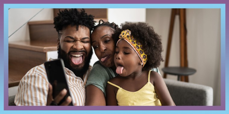 Parents with daughter taking a selfie on smartphone sticking out tongue at home