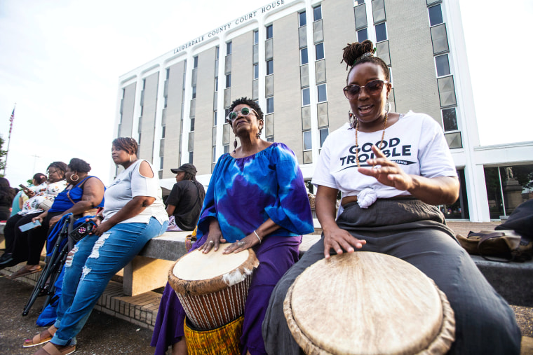 Vicki Goldston, center, and LaQuanda Simpson, right, play African drums