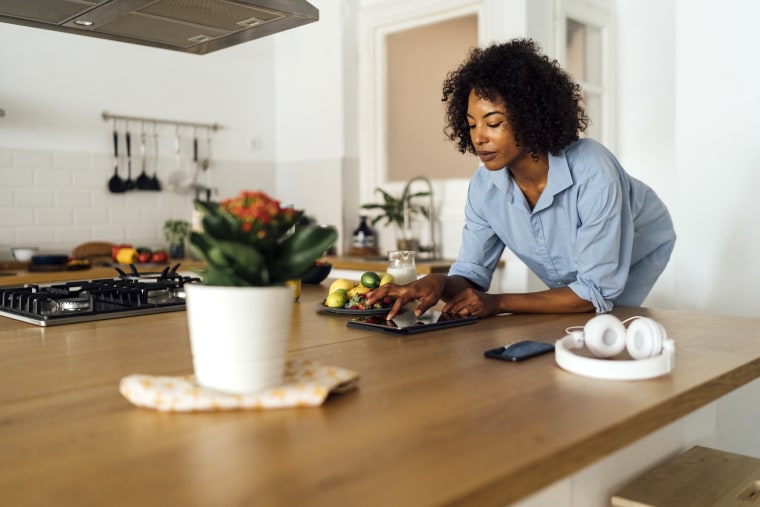 Woman using digital tablet and having a healthy breakfast in her kitchen. Find the best Wyze security and smart home products. Go with the classic Wyze camera, or shop other items like the Wyze Thermostat, Wyze Plug and more.