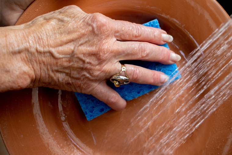 Image: Margo Woodacre washes dishes at home in Landenberg, Pa., on June 10, 2021.