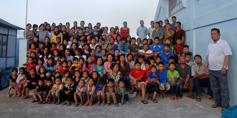 Image: Ziona's family members pose for group photograph outside their residence in Baktawng village in the northeastern Indian state of Mizoram,