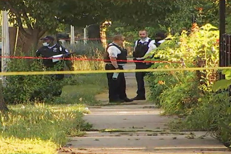 Police officers inspect the scene of a shooting in Chicago's Englewood neighborhood on June 15, 2021.