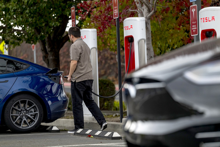 A person prepares to charge a Tesla Inc. vehicle at a charging station in Richmond, Calif., on Nov. 17, 2020.