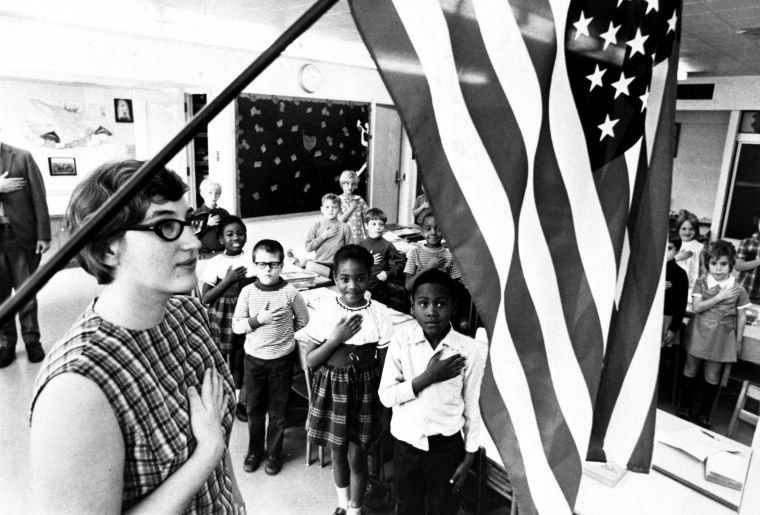 Image: A school teacher and her class recite the pledge of allegiance in Cincinnati, Ohio, c. 1970.