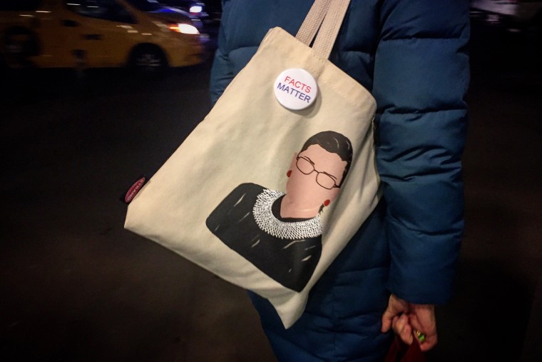 Image: A woman carries an RGB tote bag with a pin that reads, "Facts Matter" in New York City on Dec. 20, 21017.