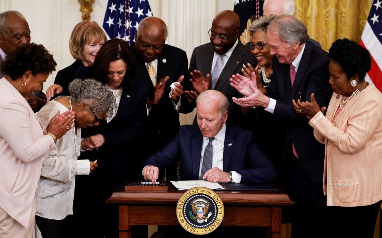 President Joe Biden is applauded as he reaches for a pen to sign the Juneteenth National Independence Day Act into law at the White House on June 17, 2021.