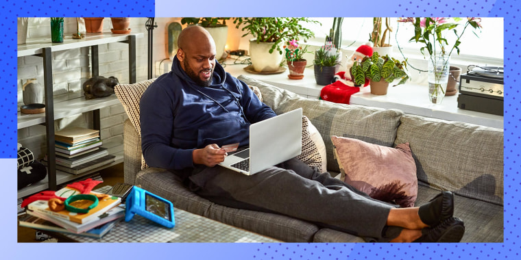 Man using laptop with feet up on sofa