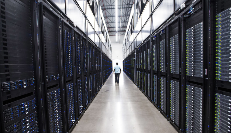 The senior site operations manager at the Apple Data Center in Mesa makes his way past dozens of servers on Aug. 14, 2018.