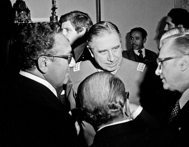 Former U.S Minister of Foreign Affairs Henry Kissinger, left, and General Augusto Pinochet, center, stand with two unidentified men in this undated file photo.