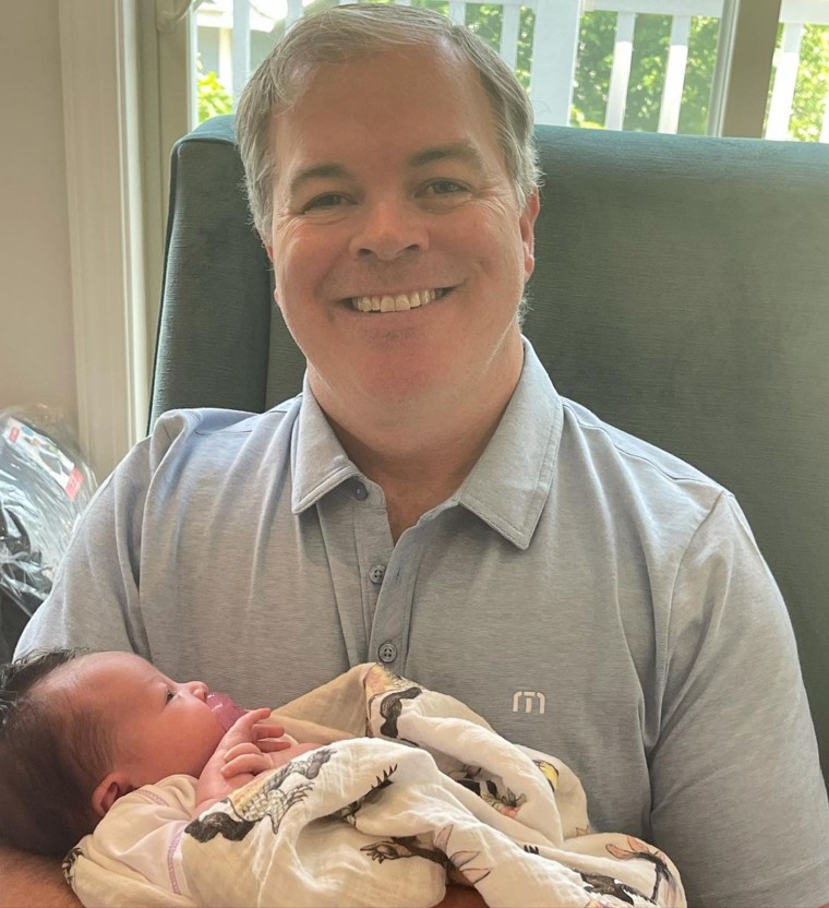 John cracks as a smile as he celebrates his first Father's Day.