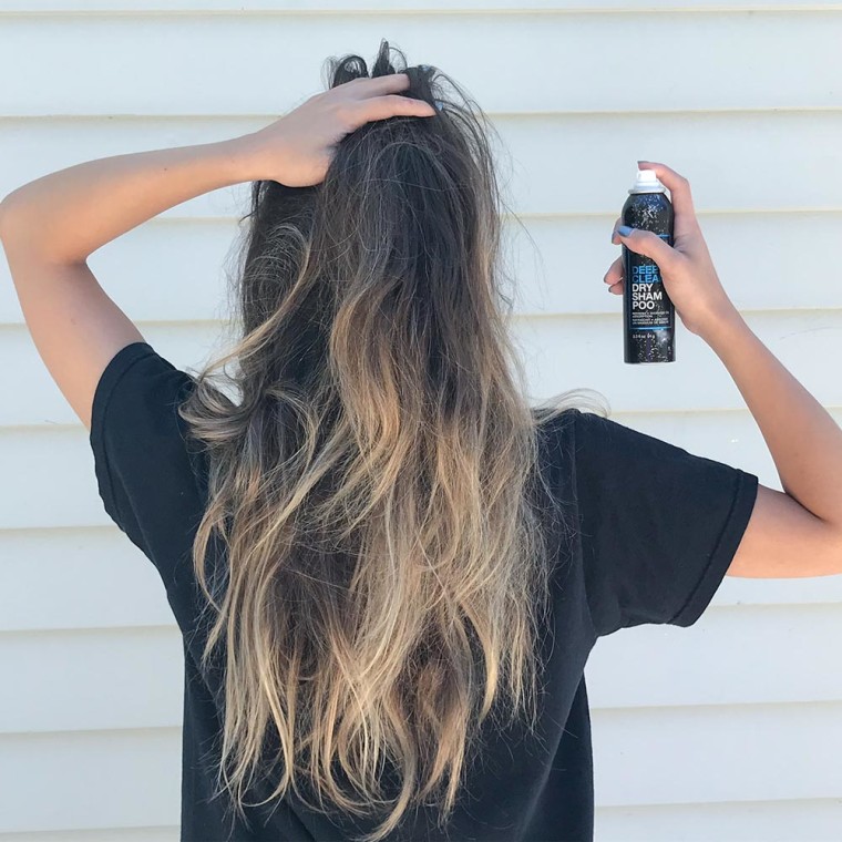 Cailey Rizzo spraying Redken dry shampoo in her hair