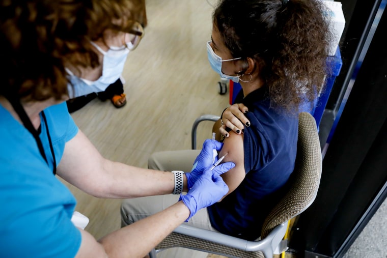 A healthcare worker administers a dose of the Pfizer-BioNTech Covid-19 vaccine to a teenager at Holtz Children's Hospital in Miami on May 18, 2021.