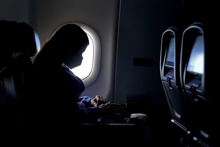 A passenger wears a face mask she travels on a flight from Hartsfield-Jackson International Airport in Atlanta on Feb. 3, 2021.